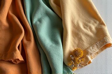 Tissus teints avec des colorants naturels, présentant des nuances subtiles et des effets tie-dye artistiques, issus de procédés végétaux.